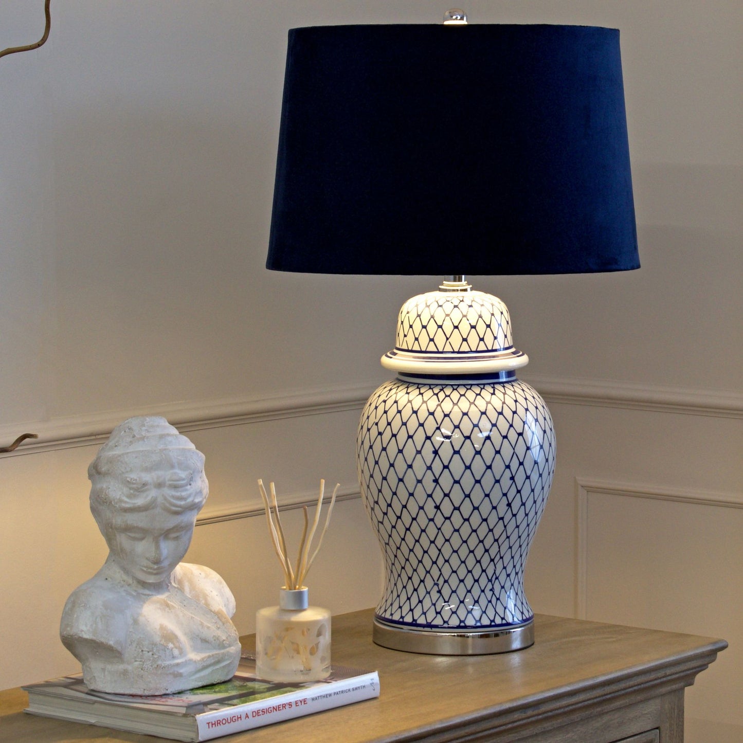 Serenity Blue And White Ceramic Table Lamp With Blue Velvet Shade and hand-painted and glazed ginger jar-shaped ceramic base.