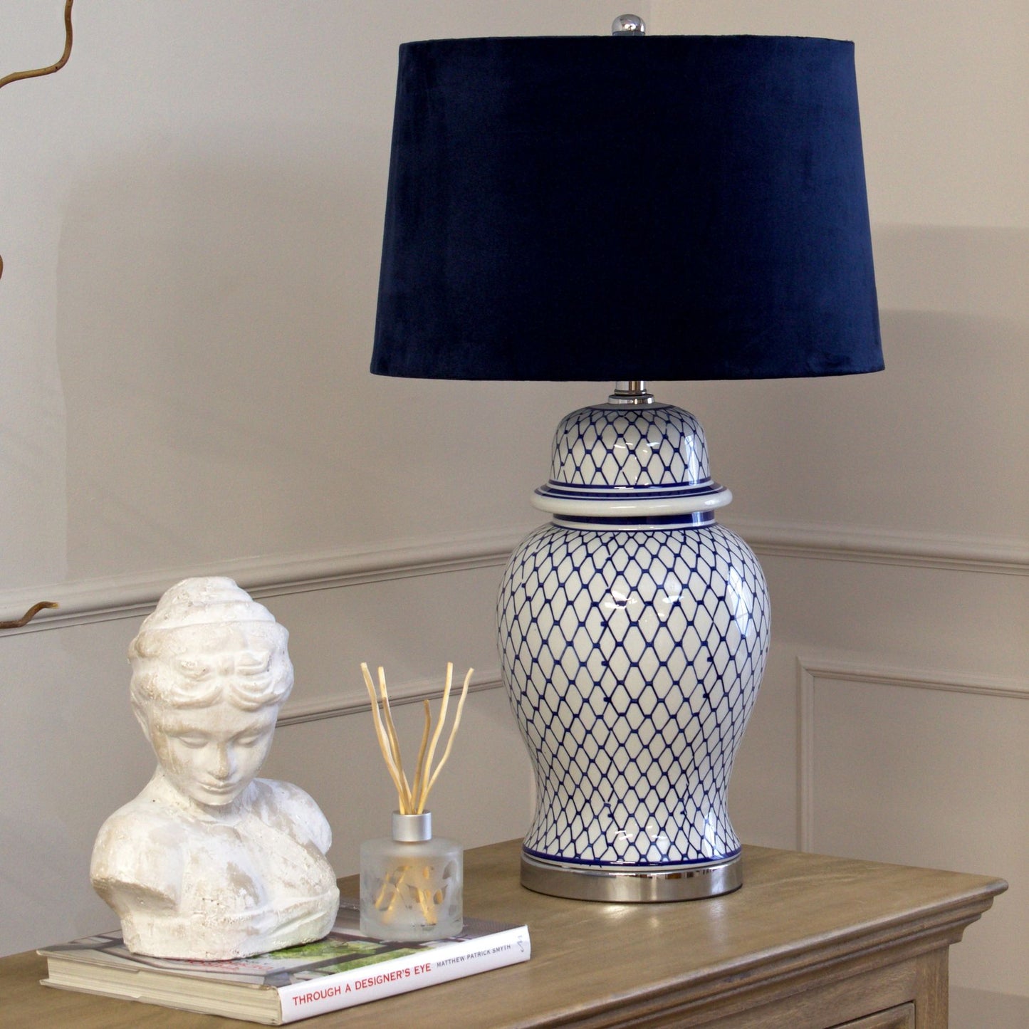 Serenity Blue And White Ceramic Table Lamp With Blue Velvet Shade and hand-painted and glazed ginger jar-shaped ceramic base.